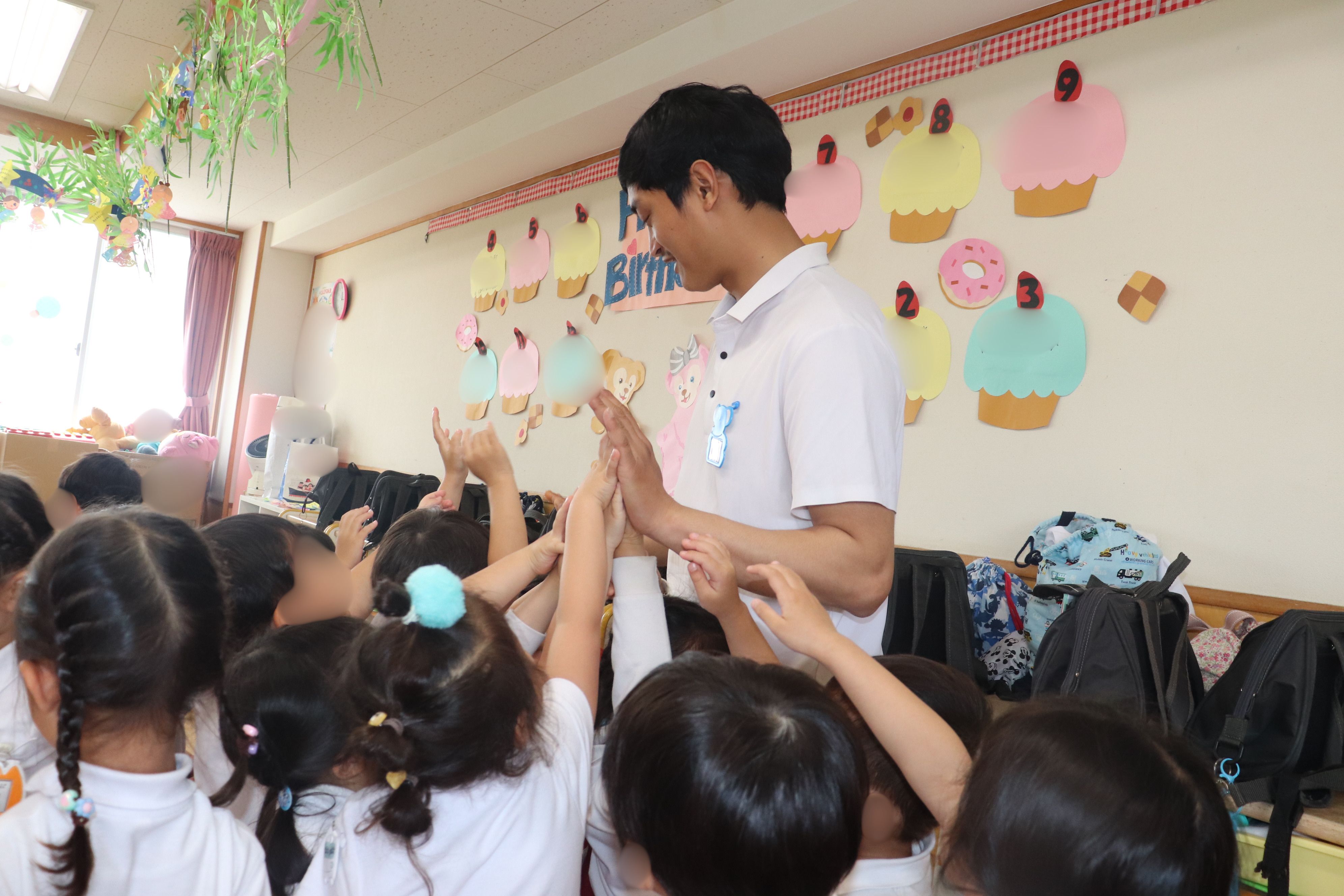 園児たちとハイタッチ!する学生の様子